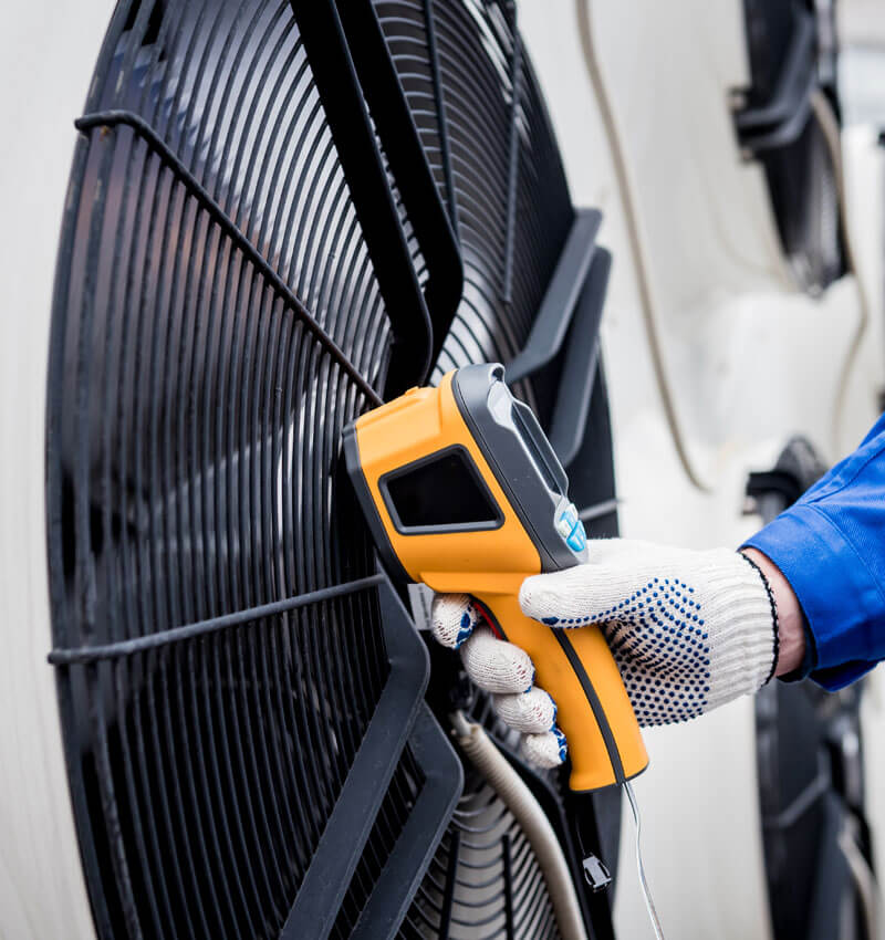 Technician Uses A Thermal Imaging Infrared Thermometer To Check The Condensing Unit Heat Exchanger.