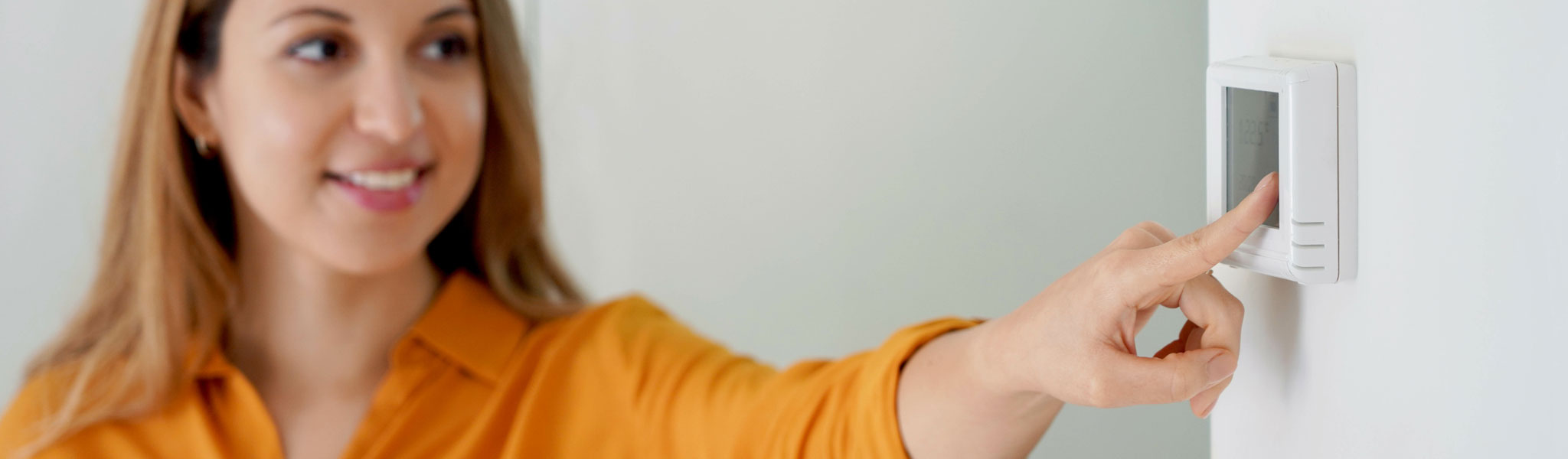 Woman Setting Thermostat